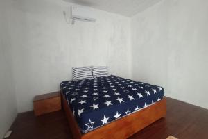 Una cama con una manta azul con estrellas. en OYO 93737 Bale Oyan Homestay en Kuta Lombok
