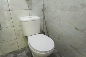 a bathroom with a white toilet in a room at OYO 93737 Bale Oyan Homestay in Kuta Lombok