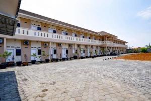 a large building with a courtyard in front of it at Hotel O Pondok Zamzam Near Taman Arung Palakka, Bone in Pakato