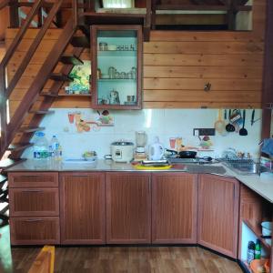 a kitchen with wooden cabinets and a staircase at Kaba Saradiel Cabin in Mawanella +26 photos