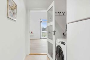 JægersprisにあるBrand New And Modern Summer House In Kulhuseの白いランドリールーム(洗濯機、乾燥機付)