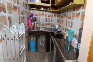een keuken met een wastafel en een aanrecht bij OYO 93753 Rafira Losmen in Rantau