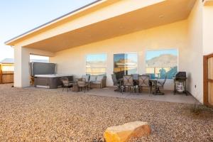 un patio con tavolo, sedie e griglia di Tranquil luxury with desert majesty a Kanab