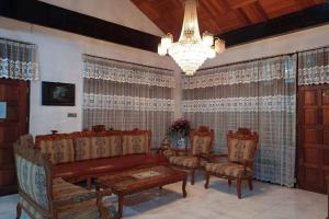 a living room with a couch and chairs and a chandelier at OYO 93706 Penginapan Syariah Hj. Kenan in Bukittinggi
