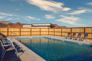 una piscina con sedie e recinzione di Tranquil luxury with desert majesty a Kanab