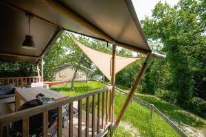 eine Veranda mit einem großen Sonnenschirm auf dem Deck in der Unterkunft Glamping San Marino in San Marino