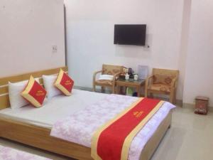 una camera da letto con un letto con due sedie e una televisione di Kim Ngân Hotel Lào Cai a Lao Cai