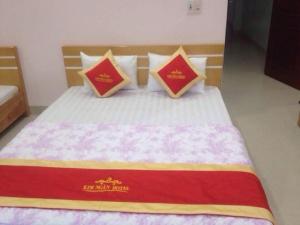 un letto con cuscini rossi e gialli di Kim Ngân Hotel Lào Cai a Lao Cai