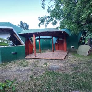 ein Haus mit einer Holzterrasse im Hof in der Unterkunft Puelo EnDomos in Lago Puelo