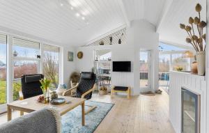 a living room with a table and a fireplace at 2 Bedroom Stunning Home In Rudkbing in Spodsbjerg