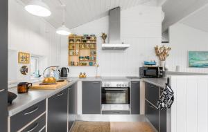 a kitchen with gray cabinets and a stove top oven at 2 Bedroom Lovely Home In Rudkøbing in Spodsbjerg