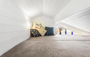 a white room with a bed with pillows at 2 Bedroom Lovely Home In Rudkøbing in Spodsbjerg +7 photos