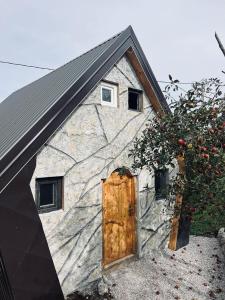 a stone building with a door and a tree at Chalet Wood Magic in Kolašin