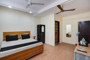 sypialnia z łóżkiem i wentylatorem sufitowym w obiekcie OYO Lotus Inn w Nowym Delhi