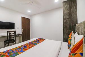 a bedroom with a bed and a desk with a chair at FabExpress Super 8 Residency in New Delhi
