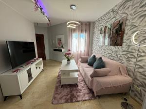 Una sala de estar con un sofá y un televisor de pantalla plana. en Ronda Centro - Glamour, en Ronda