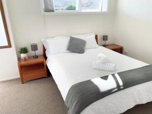 Un dormitorio con una cama con una toalla. en Your home at Cockle Bay en Auckland