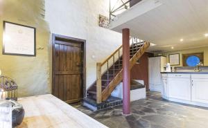 une grande chambre avec un escalier et une cuisine dans l'établissement Le Cottage du Roy, à Gouvy