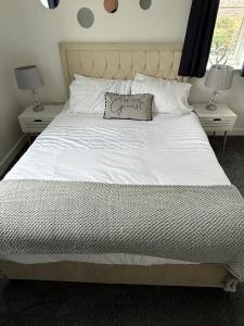 a large white bed with a pillow on it at Cathedral Apartment in Lichfield
