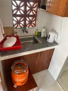 a small kitchen with a sink and a toaster at Quaint one bedroom guest house near main airport in Nairobi