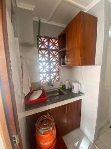 a small kitchen with a sink and a window at Quaint one bedroom guest house near main airport in Nairobi