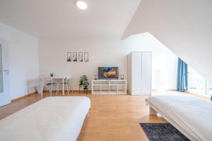 Habitación blanca con 2 camas y TV. en Nice Apartment in Blankenfelde-Mahlow, en Blankenfelde