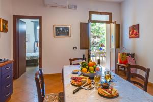 a table with a bowl of fruit and wine glasses at Case Vacanze Castellana Iris in Sciacca