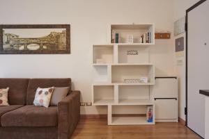 a living room with a couch and white shelves at Casa Gordigiani - bilocali con parcheggio in Florence