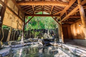 a swimming pool in a house with a wooden ceiling at Shinzan Kinosaki in Toyooka