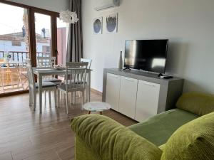 a living room with a couch and a table with a television at Apartamentos LOSA RURAL 
