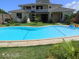 a swimming pool in front of a house at Lisa Mari in Mombasa