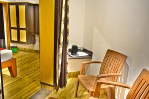 Zimmer mit 2 Stühlen, einem Tisch und einer Küche in der Unterkunft Peters Park in Yelagiri