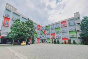 a large apartment building with red and green windows at TOS Residence Near Gading Serpong in Kampung Sawah
