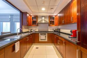 a kitchen with wooden cabinets and a sink at Spectacular Burj Khalifa & Fountain View 2 Bedroom Apartment, 29 Boulevard Tower in Dubai