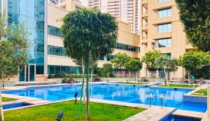 a swimming pool in front of a tall building at Spectacular Burj Khalifa & Fountain View 2 Bedroom Apartment, 29 Boulevard Tower in Dubai