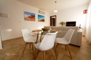 sala de estar con mesa y sillas blancas en Hacienda Laguna Seca - Apart. Lavanda, en Chiclana de la Frontera