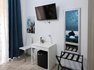 a white room with a desk and a tv on the wall at Relais Villa Borghese in Rome