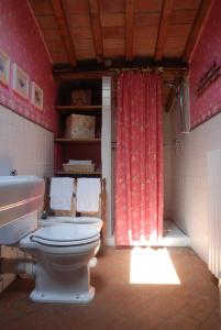 baño con aseo, lavabo y cortina roja en Podere Le Murella, en Palaia