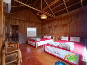 a room with three beds in a wooden room at Đảo Chè Thanh Chương - Homestay Gió Lào in Trai Ðỏ