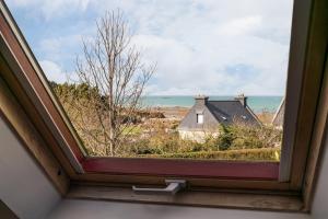 an open window with a view of the ocean at La Maison Bleue - 300m de la mer in Pleubian