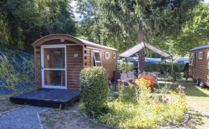 uma pequena cabana com uma porta num jardim em A La Rencontre Du Soleil - Camping em Le Bourg-dʼOisans