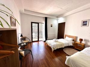 a bedroom with two beds and a wooden floor at "White House Nakani" - Guesthouse near the centre in Mestia