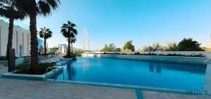 a large swimming pool with palm trees in front of a building at Serene 1BR at The Address Residences in JBR by Deluxe Holiday Homes in Dubai