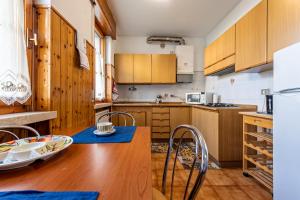 a kitchen with wooden cabinets and a wooden table with chairs at Vacanze Francesca in Bussolengo