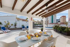 a dining room with a table and chairs on a patio at Villa Baobab - Plusholidays in Ifach
