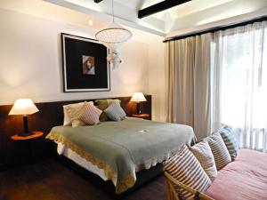 een slaapkamer met een bed, 2 lampen en een raam bij Baan Saen Fang Chiang Mai - SHA Plus in Chiang Mai