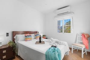a bedroom with a large white bed and a window at Villa Baobab - Plusholidays in Ifach +33 photos
