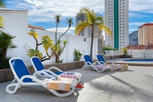 a group of chairs on a patio with a pool at Villa Baobab - Plusholidays in Ifach