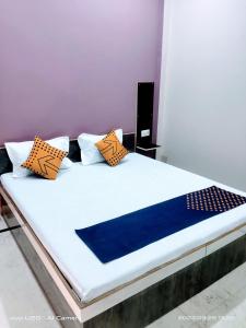 ein Bett mit orangefarbenen und blauen Kissen darauf in der Unterkunft Dream house in Ajmer