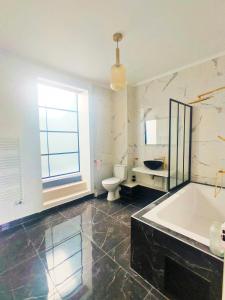Un baño con bañera, inodoro y ventana. en Villa Paris et parc d'expostions stade de France, en Aulnay-sous-Bois 35 fotos más